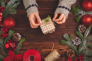 Woman wrapping DIY gift with twine for Christmas